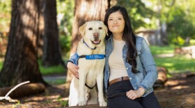 Megan Yee posing with her service dog Sir.