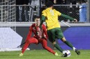 A soccer goalkeeper defends against another player moving ahead with the ball
