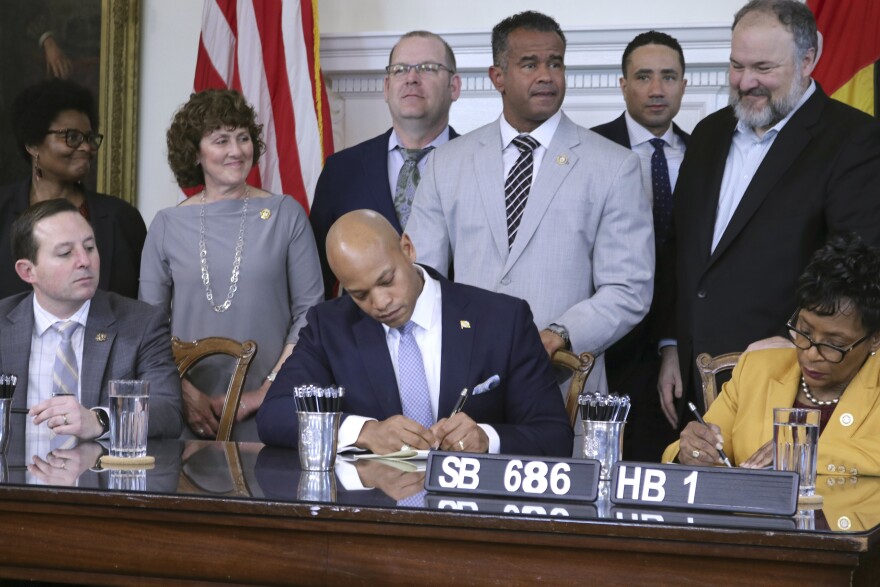 Maryland Gov. Wes Moore signs a bill to end the state's statute of limitations for when lawsuits can be filed against institutions for child sexual abuse during a ceremony on Tuesday, April 11, 2023, in Annapolis, Md. Senate President Bill Ferguson is seated left, and House Speaker Adrienne Jones is seated right. Standing from right are Del. Luke Clippinger, Sen. Will Smith and Del. C.T. Wilson, the bill's House sponsor who is standing behind the governor. (AP Photo/Brian Witte)