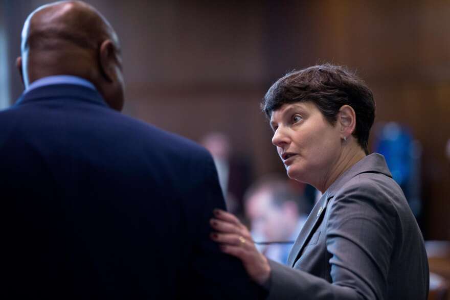 Elizabeth Steiner is speaking to someone with their back turned to the camera.