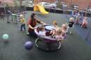 Day care staff member pushes toddlers on a teacup merry-go-round playground toy. (Leah Willingham/AP)