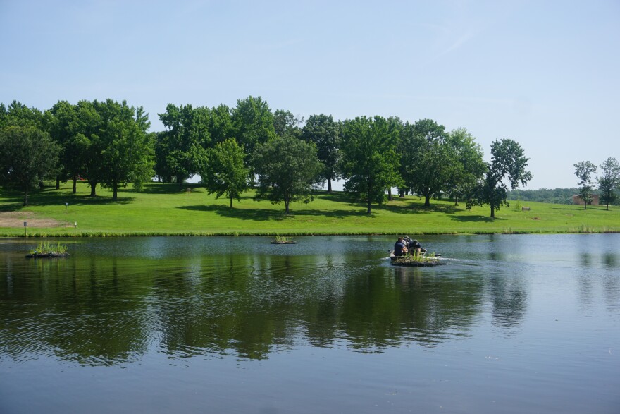 Workers from the Missouri Department of Conservation and the Rolla Parks Department work on one of the floating wetlands in Ber Juan Lake.