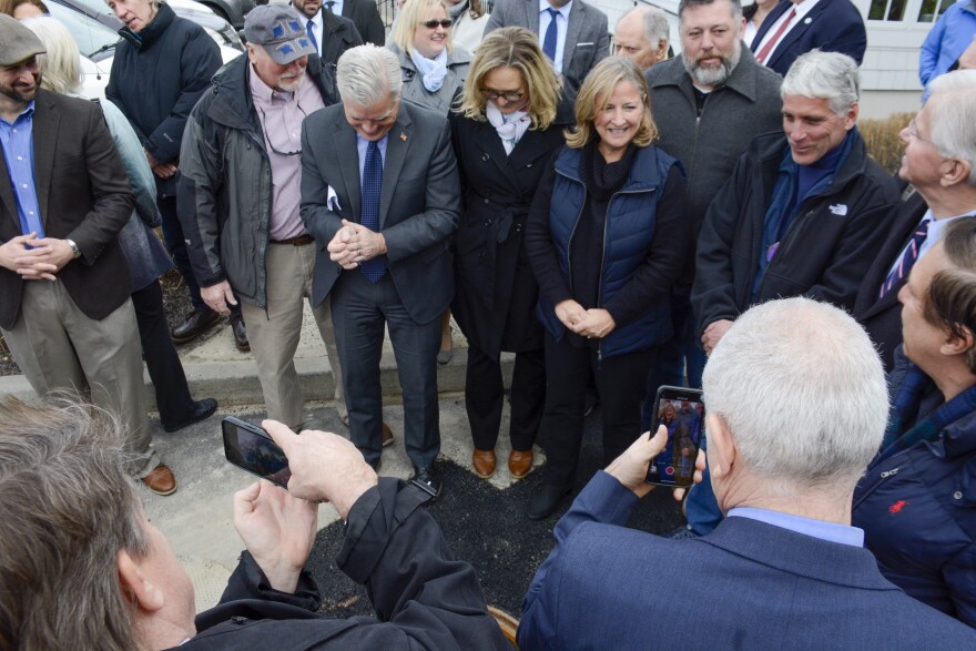 Standing over an open manhole, officials applaud the "first flush" of Westhampton Beach's new sewer connection to Suffolk County's wastewater treatment plant at Francis S. Gebraski Airport.