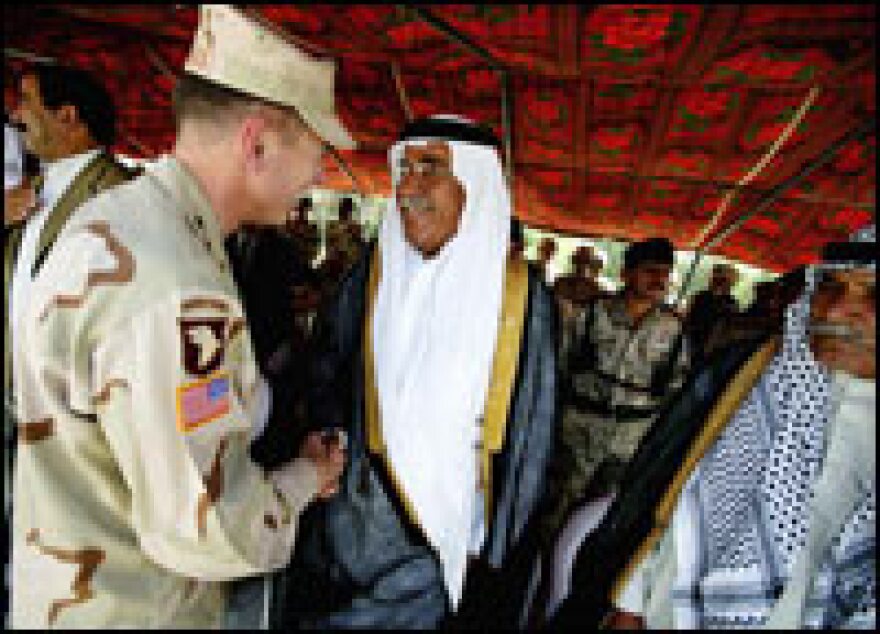 Lt. Gen. David Petraeus (left) meets local dignitaries while visiting a coalition base in Tikrit, Iraq, June 10, 2004.