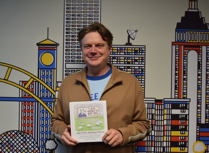 Cartoonist Paul Noth holds a copy of his debut cartoon collection "I Am Going to Eat You… And Other Awkward Truths."