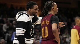 Cleveland Cavaliers guard Donovan Mitchell, left, who did not dress for the game, talks with teammate Darius Garland (10) in the second half of an NBA basketball game against the Brooklyn Nets, Tuesday, March 11, 2025, in Cleveland. (AP Photo/Sue Ogrocki)