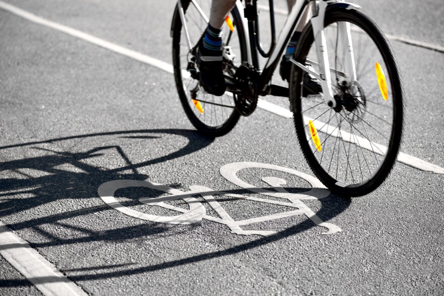 A cyclist riding in a bike lane on a road.