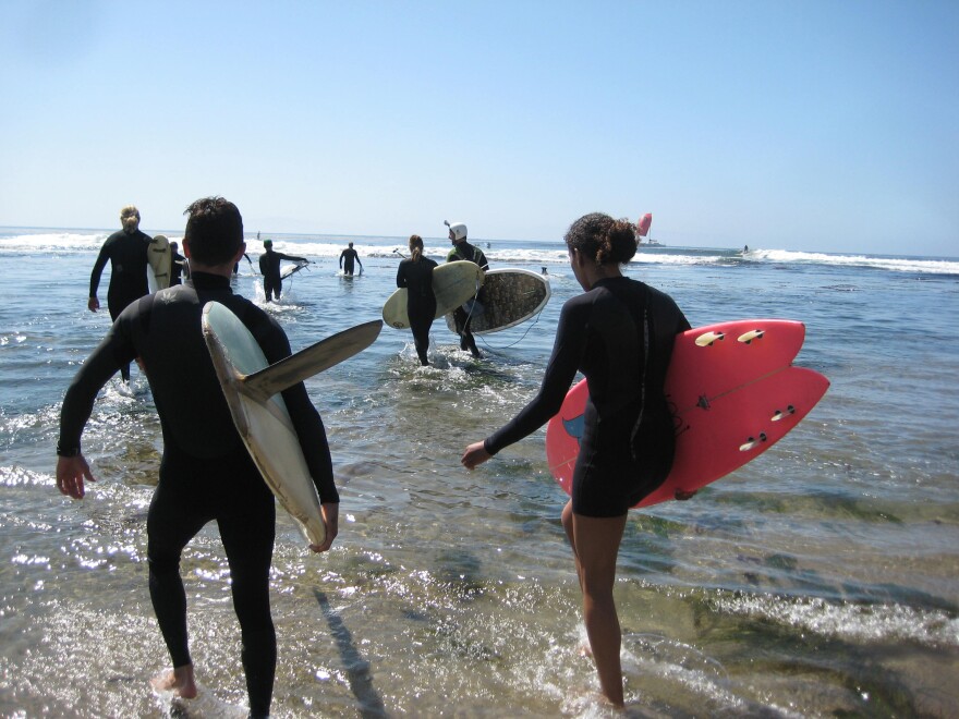 Surfers walk in the low tide waters at Pleasure Point.