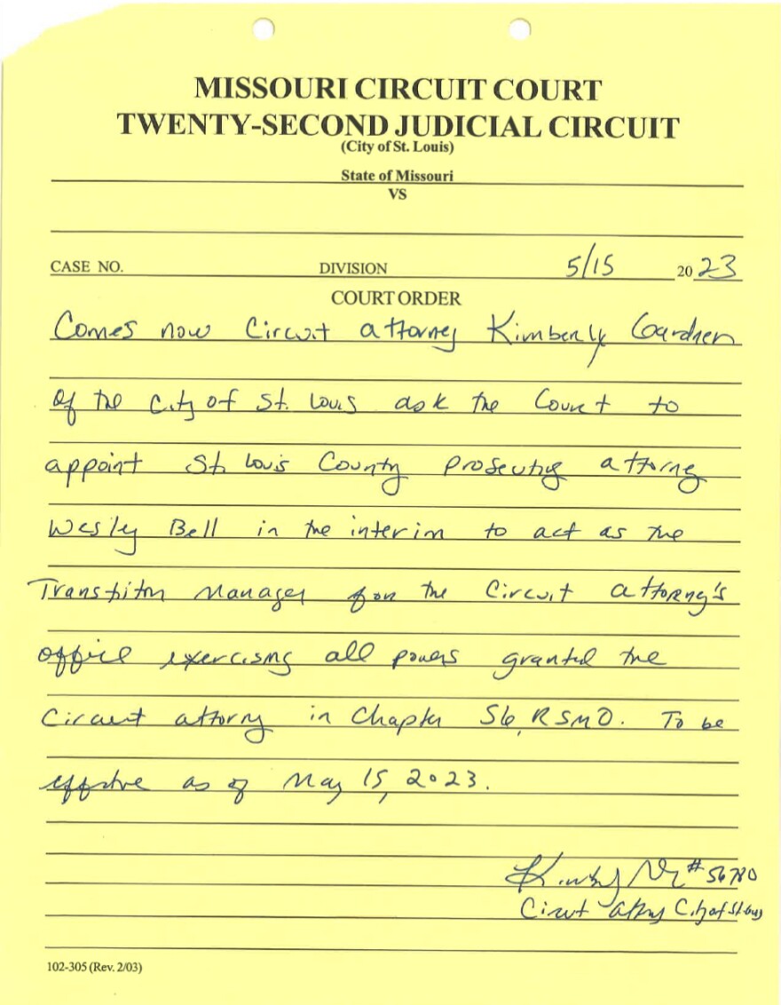 A piece of lined yellow paper from the 22nd Circuit. On it is written, "Comes now Circuit Attorney Kimberly Gardner of the city of St. Louis (asking) the court to appoint St. Louis County Prosecuting Attorney Wesley Bell in the interim to act as the transition manager for the circuit attorney's office exercising all powers granted the circuit attorney in Chapter 56 RSMO."