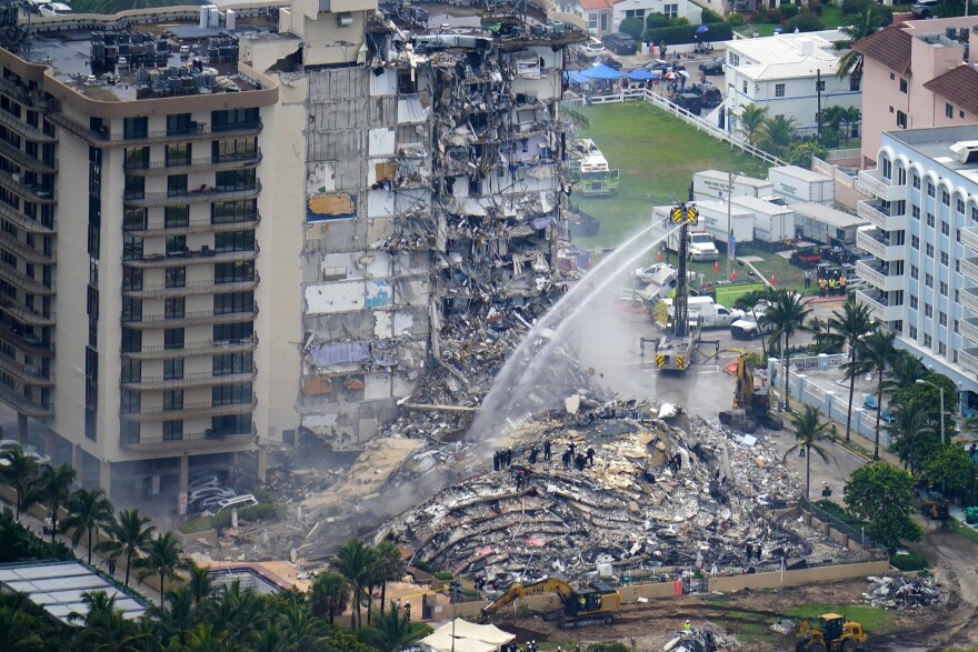 In this June 25, 2021 file photo, rescue personnel work at the remains of the Champlain Towers South condo building in Surfside, Fla. A tentative deal was announced Friday, Feb. 11, 2022 that would pay $83 million to people who lost condominium units and personal property in the collapse of a Florida building that killed 98 people.