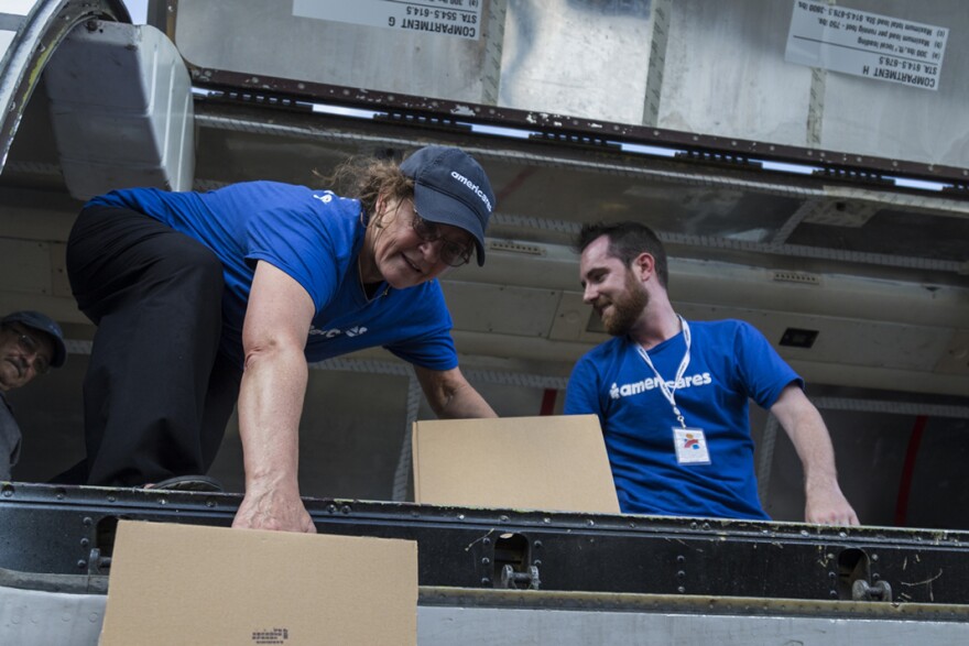 Members of Americares, including Dr. Anne Peterson (left), unload a plane containing medical supplies in San Juan this past October.