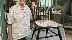 Curtis Buchanan stands next to a Windsor chair he made.