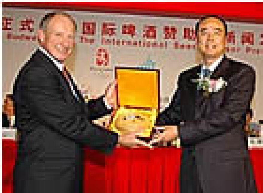 Company CEO Patrick Stokes (L) exchanges gifts with Wang Wei, with the Organizing Committee for the Beijing Games, at Tuesday's announcement. (photo from Anheuser-Busch)