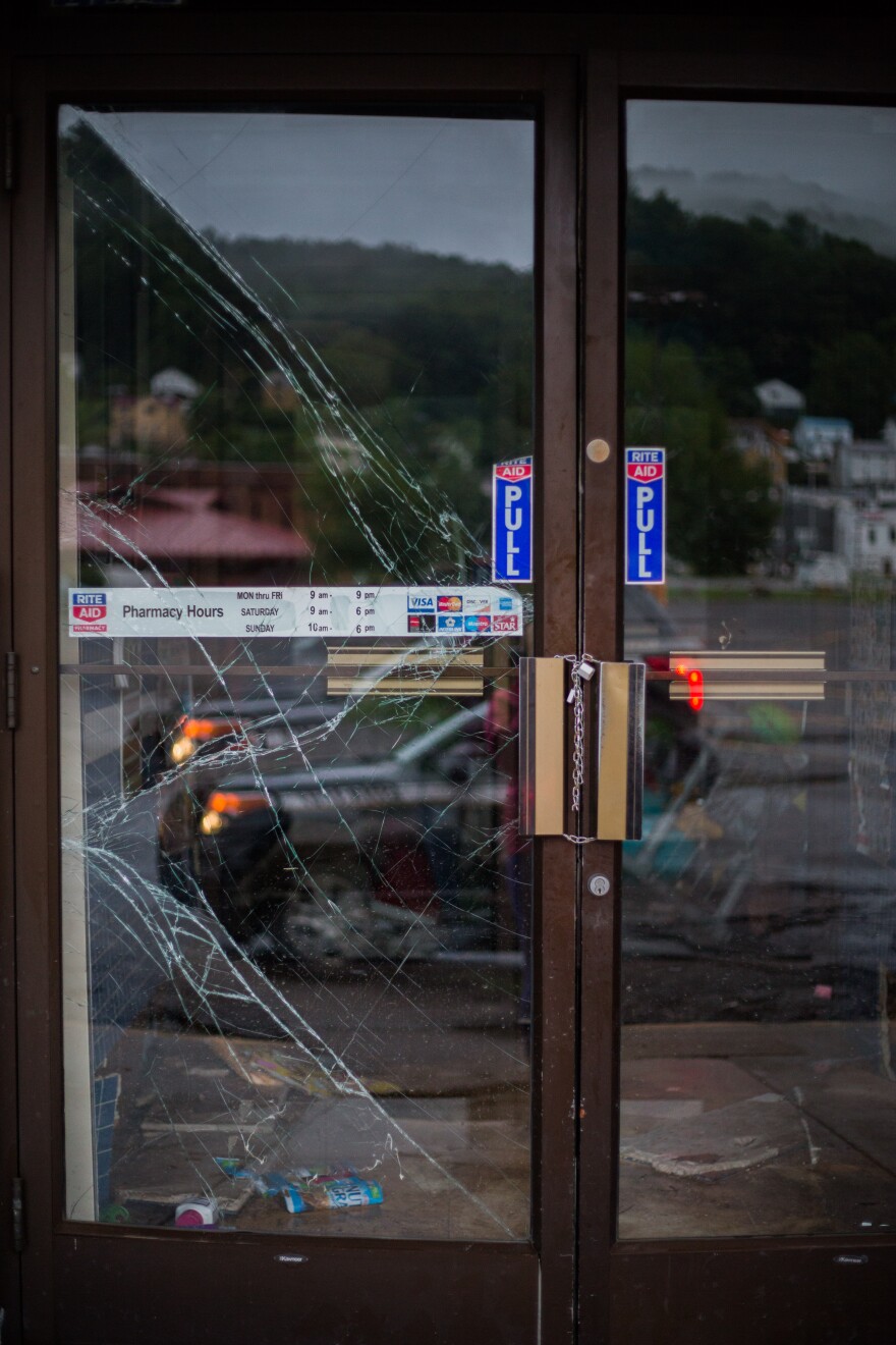 Broken Rite Aid doors are deadbolted shut early Friday morning in Richwood, WV. Rumors that the Rite Aid roof had collapsed and that the store had been looted were circulating, but could not be confirmed.