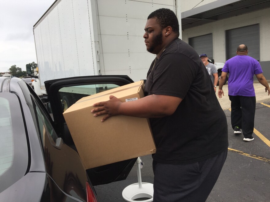 Donovan Demus loads donated household necessities into his car. His family lost their home in the Memorial Day tornado disaster. 