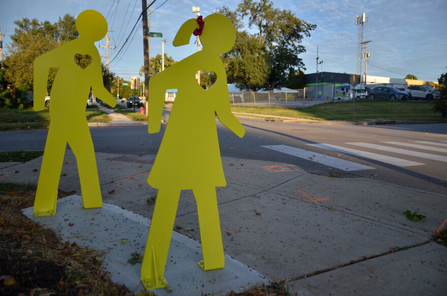 A new initiative called SafeAcross KC will install bright yellow pedestrian-shaped sculptures near 10 crosswalks across Kansas City, including a "student walker" at some locations like Hale Cook Elementary School.