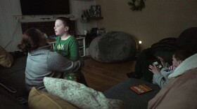 Ronan Murphy snuggles with his mom, Andrea, while looking at the snow falling outside his home while brother, Connor sits nearby in Ayer, Mass., on Saturday, Jan. 17, 2026.