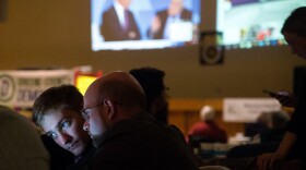 Two men's faces are lit up by a computer screen as they check election results at the Greene County Democratic watch party on Nov. 6.