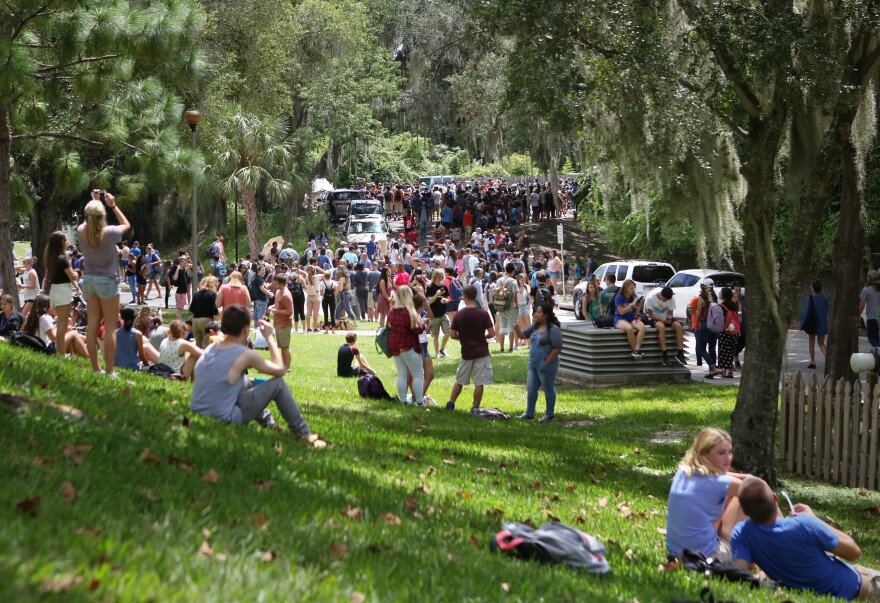 Hundreds of star-struck individuals wait in line or lounge on the hill outside of the Campus Teaching Observatory to see the eclipse on Monday. A volunteer for the event said over 500 people looked through the telescopes outside the observatory, and hundreds more waited in line. (Emma Green/WUFT News)