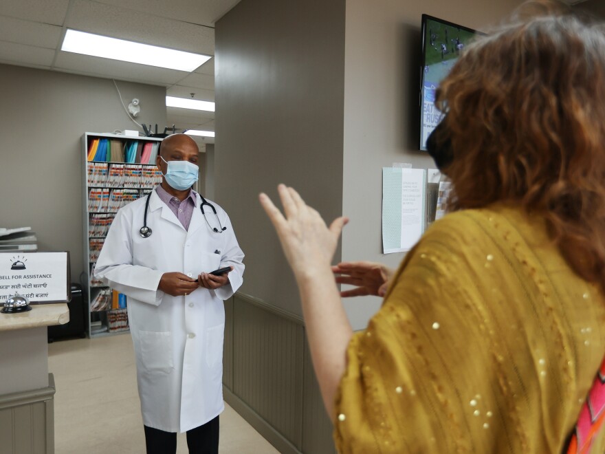 Dr. Naresh Aggarwal talks with Jennifer Bain, who volunteered for a study of Medicago's COVID-19 vaccine, in Toronto. More than 24,000 volunteers in six countries participated.