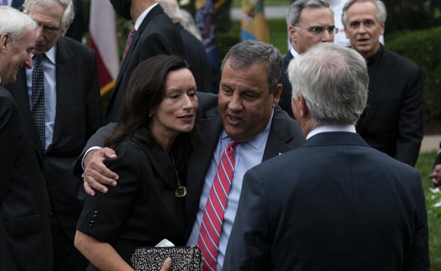 Notre Dame President the Rev. John Jenkins stands in the background at right as former New Jersey Gov. Chris Christie speaks with guests in the White House Rose Garden. Both men have tested positive for the coronavirus.