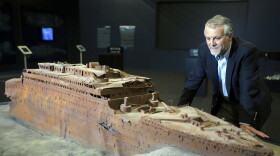 Paul-Henri Nargeolet, director of a deep ocean research project dedicated to the Titanic, poses next to a miniature version of the sunken ship inside a new exhibition, at 'Paris Expo', on May 31, 2013, in Paris. Over a century after the sinking of the famous ship, a Titanic exhibition in Paris will open to public from June 1 to September 15, and promises to present "real objects, and real stories."