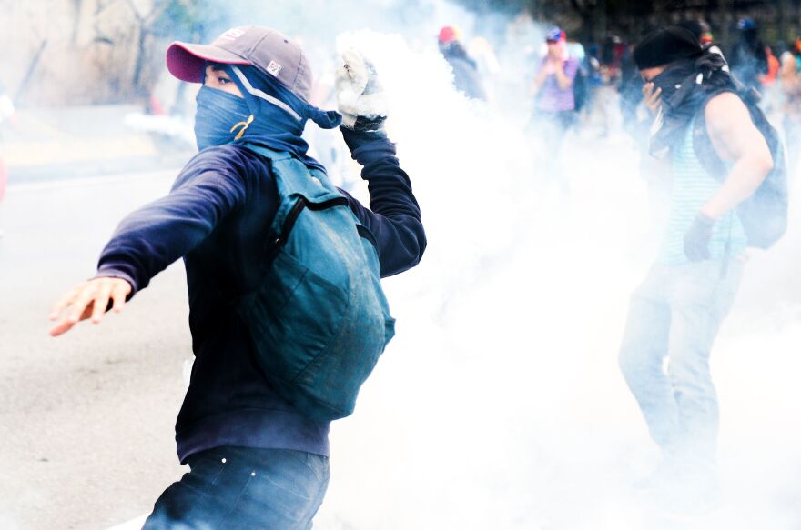 Opposition activists clash with riot police during protests Thursday. By the end of the day, a man had died of his gunshot wounds, bringing the number of people killed in past two weeks of protests to five.