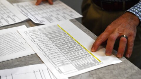 Anderson County Clerk Jason Denny looks over the printouts from the voting machines during the remcanvass of the results from the election for Kentucky Governor in Lawrenceburg, Ky., Thursday, Nov. 14, 2019. Election officials across Kentucky have started double-checking vote totals that show Republican Gov. Matt Bevin trailing Democrat Andy Beshear by more than 5,000 votes. (AP Photo/Timothy D. Easley)