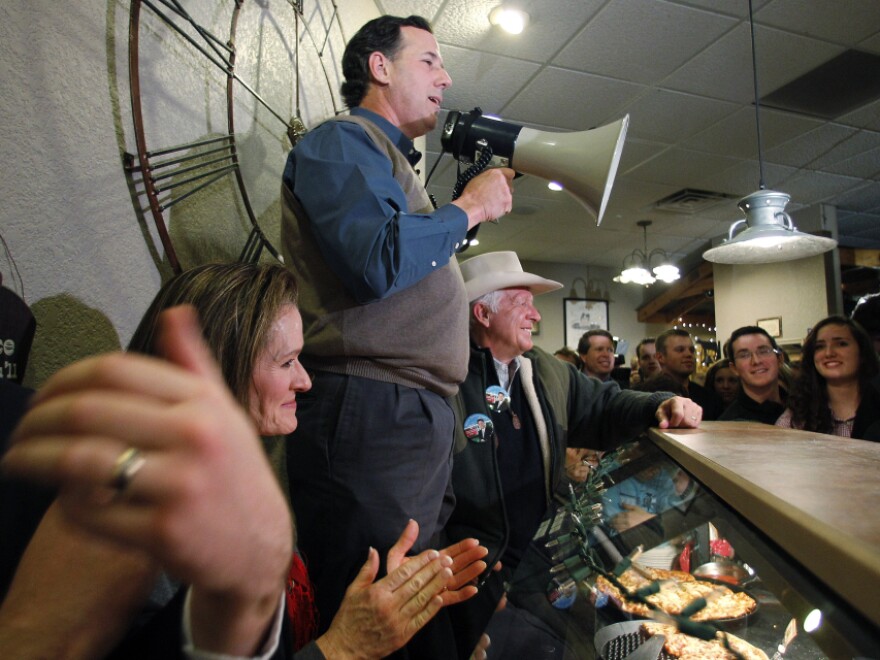 Former Pennsylvania Sen. Rick Santorum, who has recently surged in the Iowa polls, used a bullhorn during a meet-and-greet campaign stop Monday at the Pizza Ranch in Altoona, Iowa.