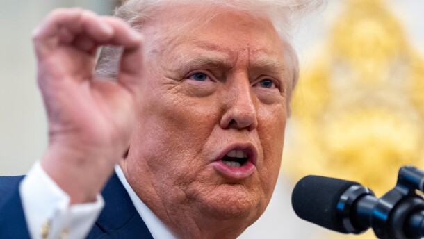 A close up of a man speaking in front of a microphone.