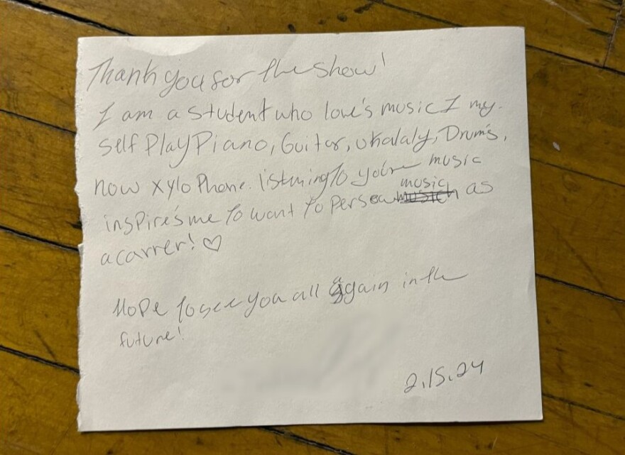 The letter has a couple spelling errors and a drawing of a heart. It reads: "Thank you for the show! I am a student who loves music. I myself play piano, guitar, ukulele, drums, and now xylophone. Listening to your music inspires me to want to persue music as a career! Hope to see you all again in the future! 2.15.24"