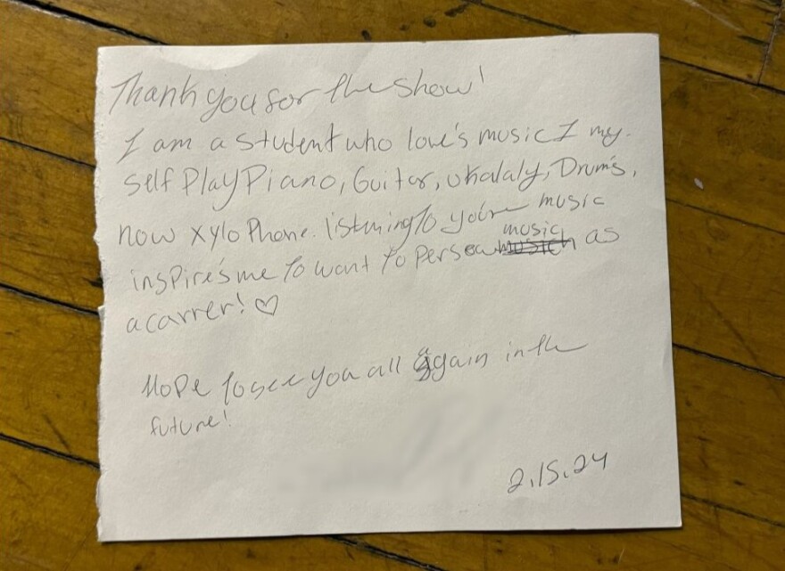 The letter has a couple spelling errors and a drawing of a heart. It reads: "Thank you for the show! I am a student who loves music. I myself play piano, guitar, ukulele, drums, and now xylophone. Listening to your music inspires me to want to persue music as a career! Hope to see you all again in the future! 2.15.24" 