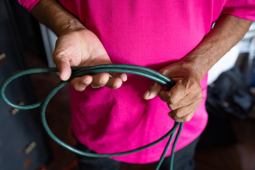 Jesús González shows the extension cable he uses to run power from the main outlet of the apartment into his bedroom to power the air conditioning unit. He says when it gets hot outside, most of the outlets in the building stop working because of the power demand.