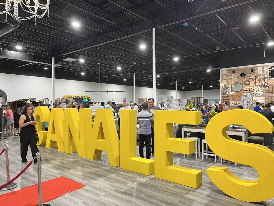 A woman walks in front of large yellow letters that read "Canales" in the showroom of Canales Legacy Shopping Center at 102 E. Interstate 20 in Arlington, Texas, July 15, 2022.