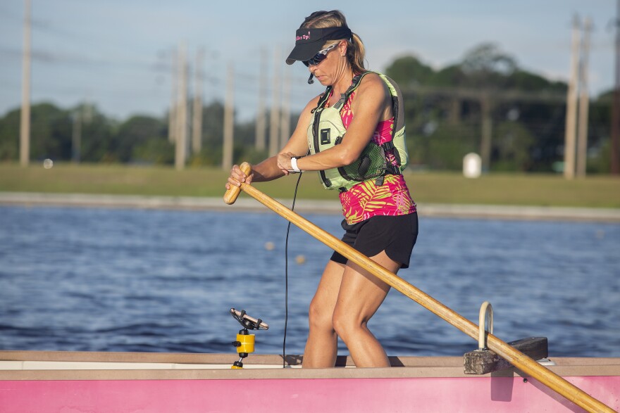 Woman standing in pink boat