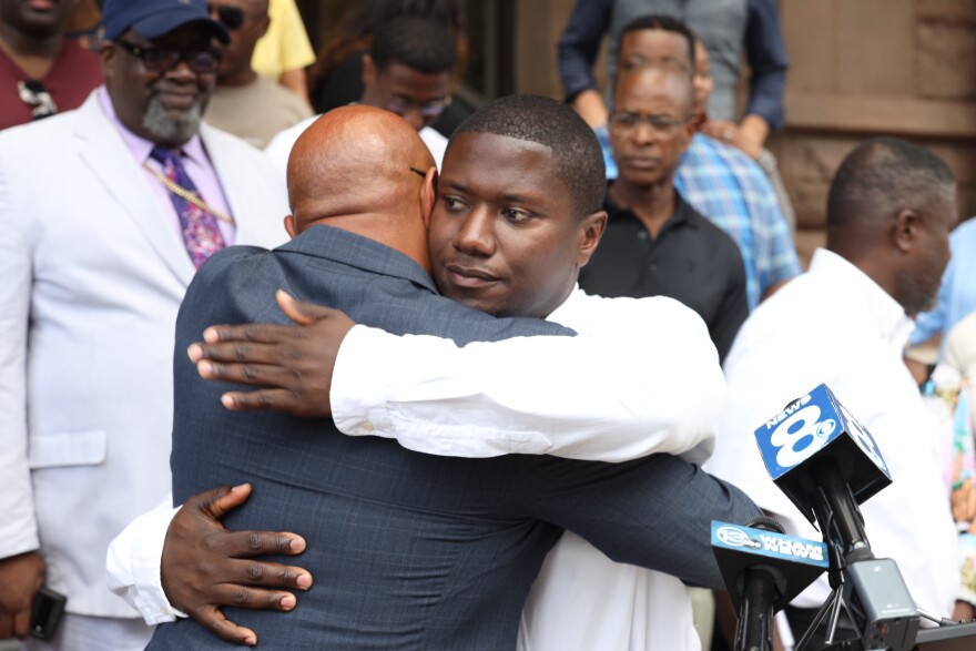 Rochester firefighter Jerrod Jones hugs his former high school English teacher, Jason Muhammad, on Thursday, Aug. 11, 2022, at a news conference where Jones said he was forced while on duty to attend a party that mocked the Juneteenth holiday.