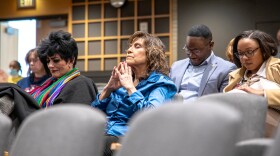 A member of the audience prays for the lives lost on flight 5342 on Jan. 29.