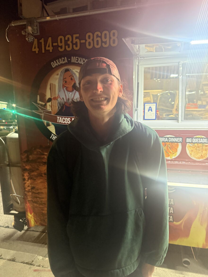 photo of a man in front of a taco truck 