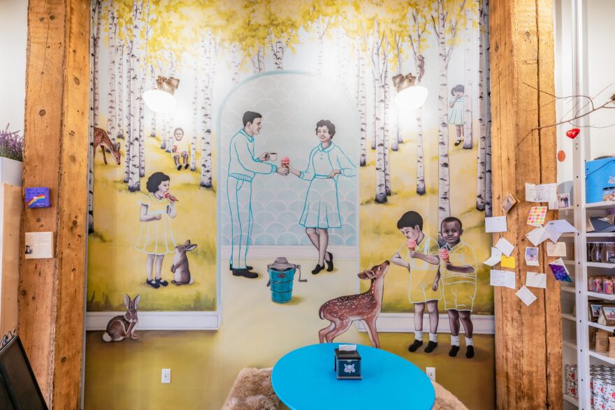 A mural of animals and people enjoying ice cream in a birch tree forest