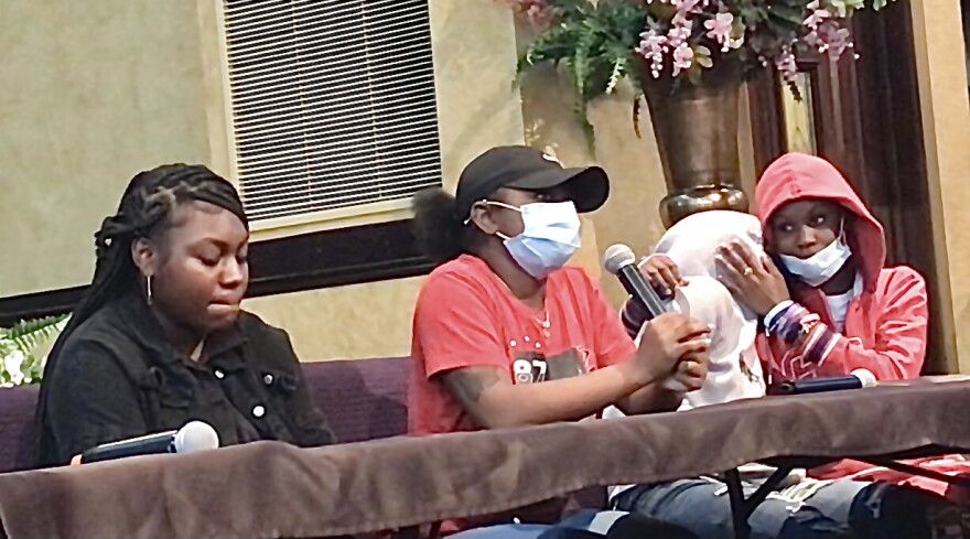 4 students sitting at a table with microphones