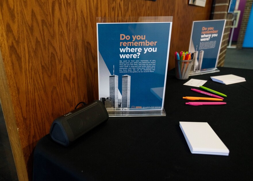 Sign, speaker, notepad and pens on display table