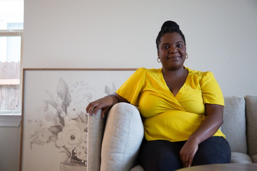 Chinenye Enenmoh, a first-time homebuyer, sits in the living room of her new home on Oct. 23, 2023. Nastassja Collak/KUT