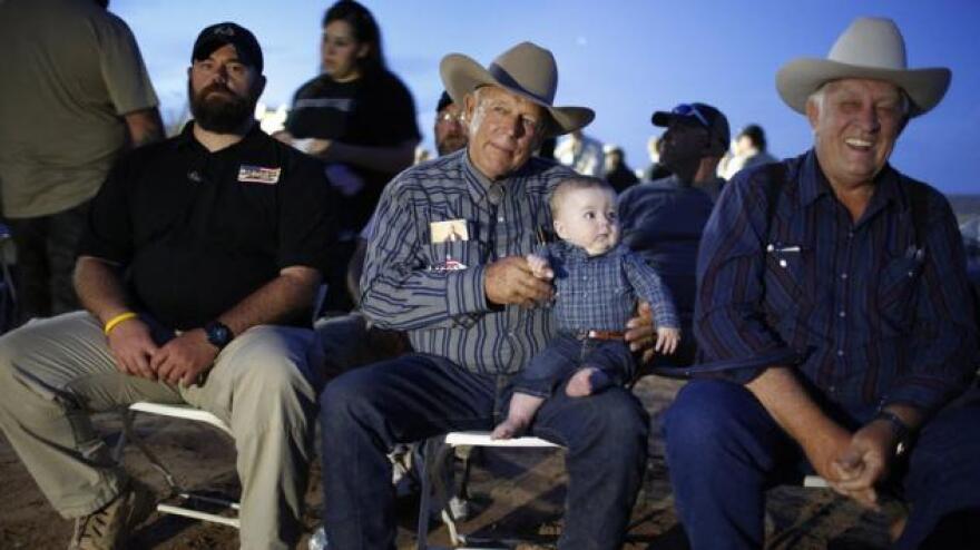 Rancher Cliven Bundy holds his 5-month-old grandson Roper Cox in April 2015 in Bunkerville, Nev. Bundy was hosting an event to mark one year since the Bureau of Land Management's failed attempt to collect his cattle.