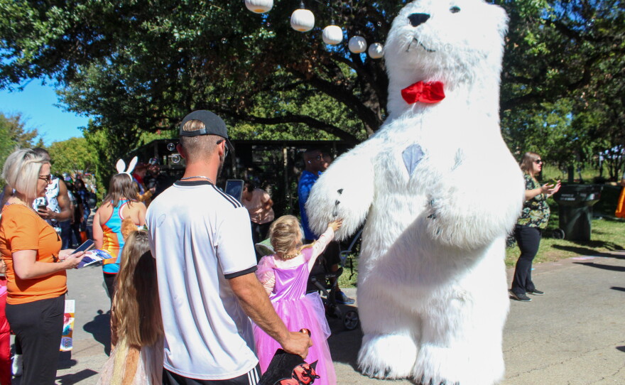 A polar bear greets children around the zoo.