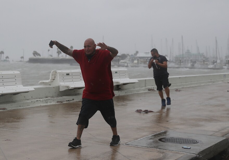 Raul Barral (left) and Carlos Guerra walk through high wind and driving rain in Corpus Christi, Texas, Tuesday as Hurricane Harvey approaches the Gulf Coast.