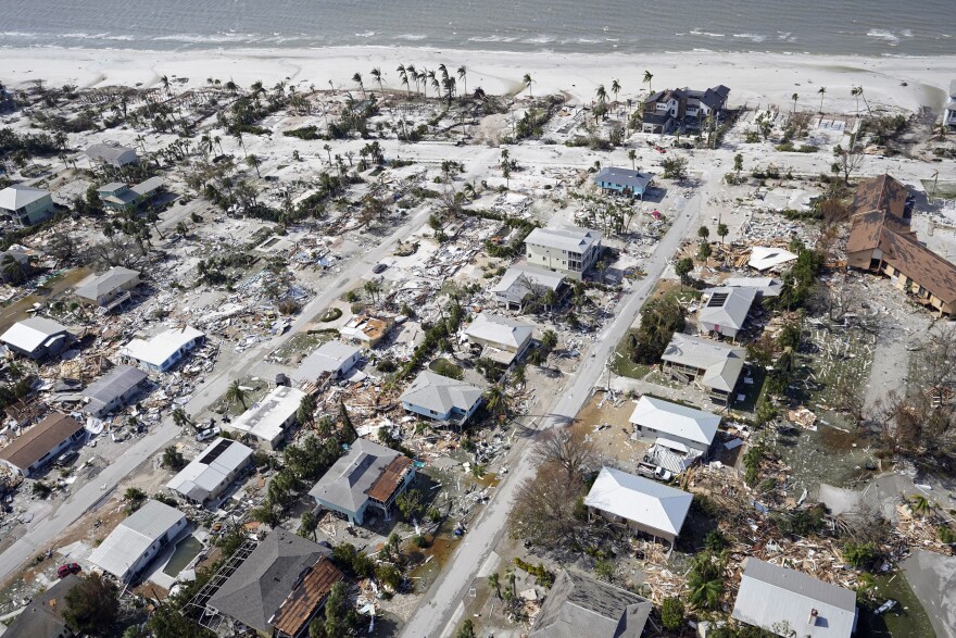 This aerial photo shows damaged homes and debris in the aftermath of Hurricane Ian, Thursday, Sept. 29, 2022, in Fort Myers, Fla. (AP Photo/Wilfredo Lee)