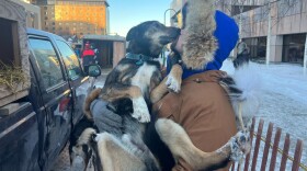 a dog gets a kiss oustide