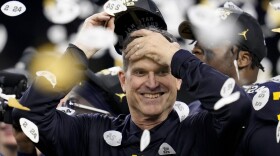 FILE - Michigan coach Jim Harbaugh celebrates the team's win in the national championship NCAA college football playoff game against Washington, Jan. 8, 2024, in Houston. Harbaugh will be the coach of the Los Angeles Chargers, leaving Michigan after capping his ninth season as coach of college football’s winningest program with the school’s first national championship since 1997, two people familiar with the situation told The Associated Press. The people spoke to the AP on condition of anonymity because the team hasn’t made the announcement. (AP Photo/Godofredo A. Vasquez, File)