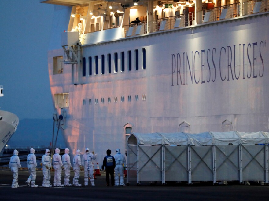 Officers wear protective gear as they work to remove people who tested positive for coronavirus from the cruise ship Diamond Princess. The ship is under quarantine at the Daikoku Pier Cruise Terminal in Yokohama, Japan.