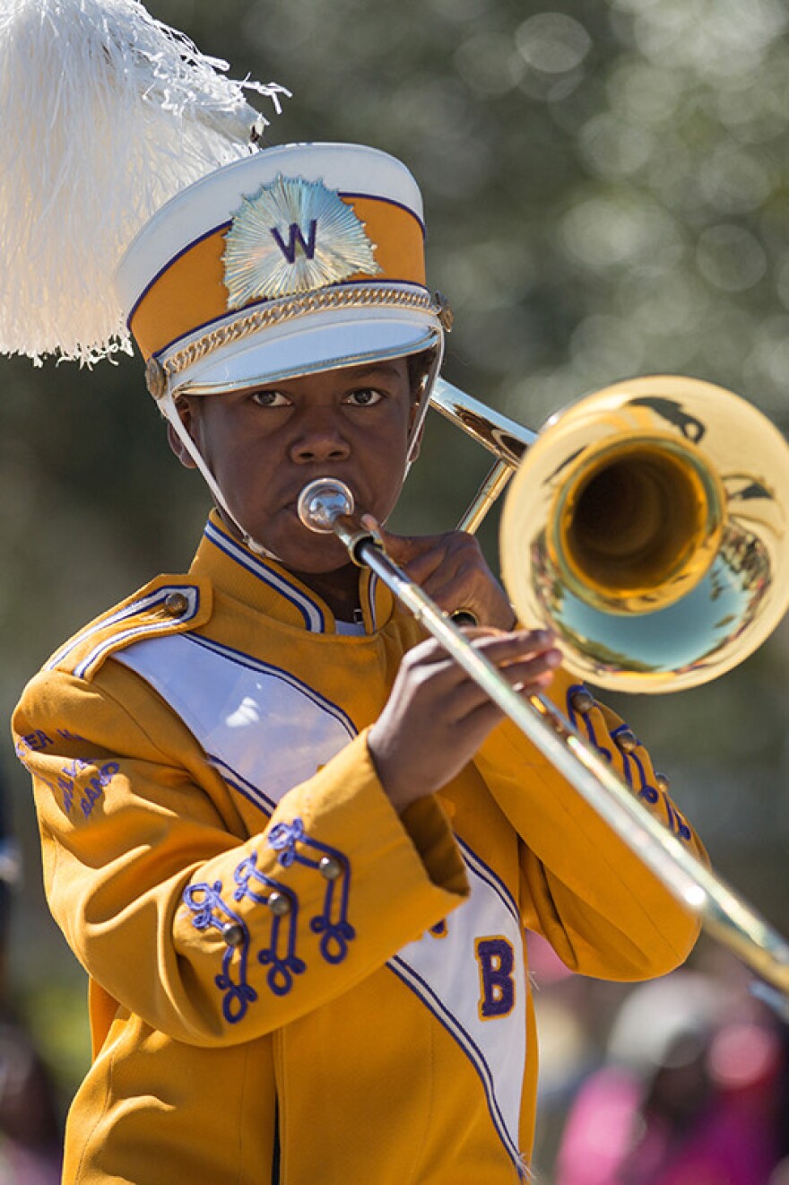 A band member plays the trombone for parade attendees.